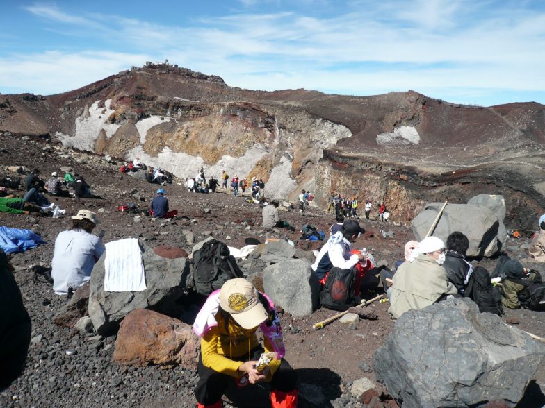 大部份登山者都累死了，坐在火山口邊休息。